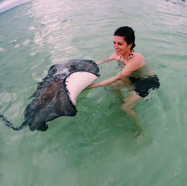 Kathy holding a string ray in the ocean waters of Grand Cayman