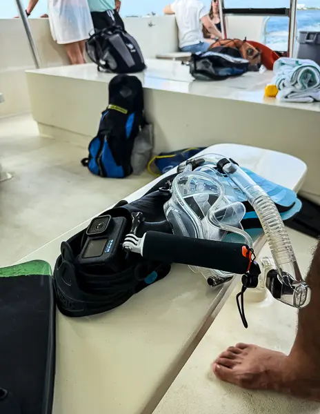 Snorkeling gear and a GoPro camera laid out on a boat in Grand Cayman before heading to the reef for a snorkeling stop.