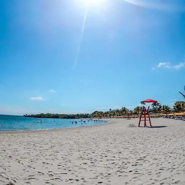 Sandy beach, blue sky and water at Harvest Caye Belize