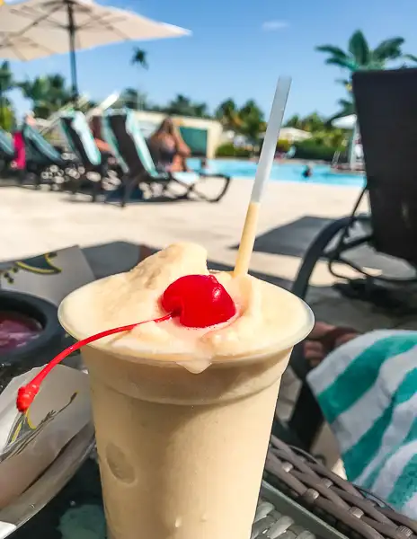 Frozen piña colada topped with a cherry by the pool at Harvest Caye, Belize, enjoyed during a port day on Norwegian Cruise Line’s private island.