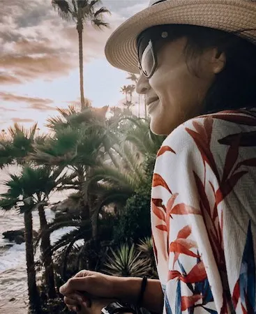 Woman admiring sunset and palm trees