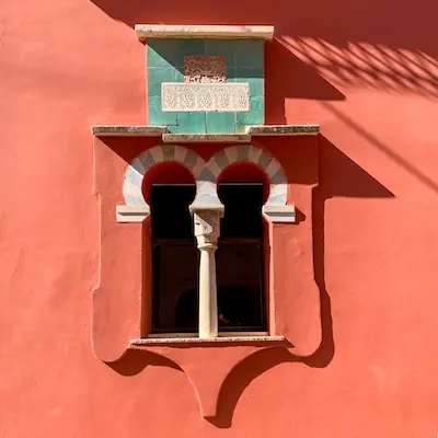 beautiful arched window against a burnt orange facade