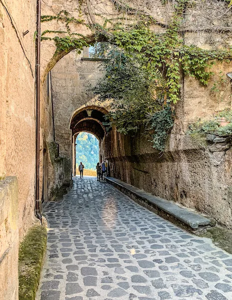 arched stone entrance with cobblestone path