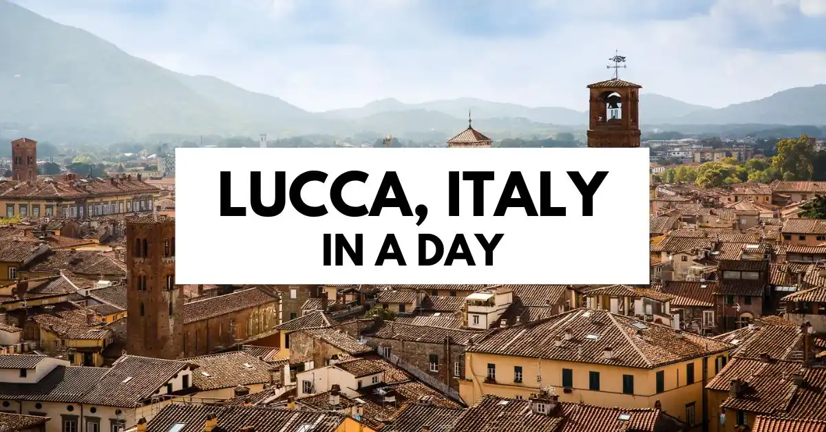 featured blog image with tex | A blog header image with the text "Lucca, Italy in a Day" over a panoramic view of Lucca's rooftops and surrounding hills.