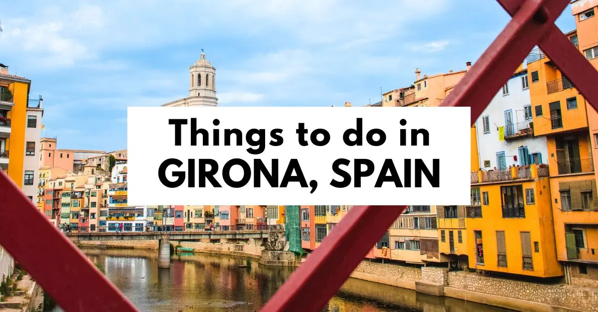 featured blog image for Girona, Spain, showing a colorful view of buildings along a river from a red bridge. The image is overlaid with text stating "Things to do in GIRONA, SPAIN.