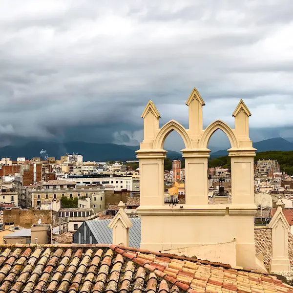 View of Girona's historic skyline and mountains beyond, seen from the city wall.