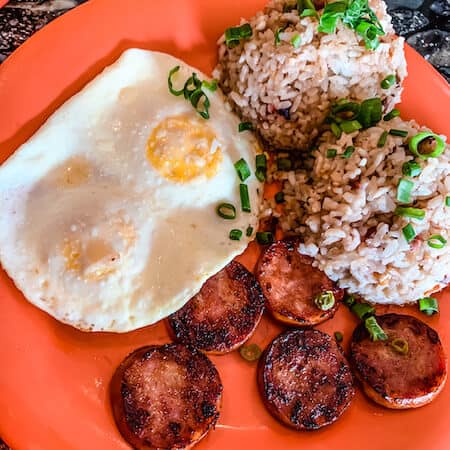 plate of fried eggs, sliced sausage and fried rice