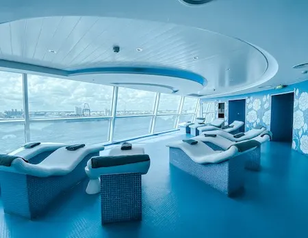 Heated loungers pointed towards large windows on a spa cruise ship