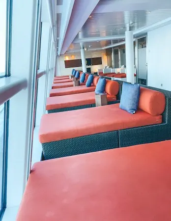 Comfortable bed like lounges pointed towards large windows in a spa cruise ship
