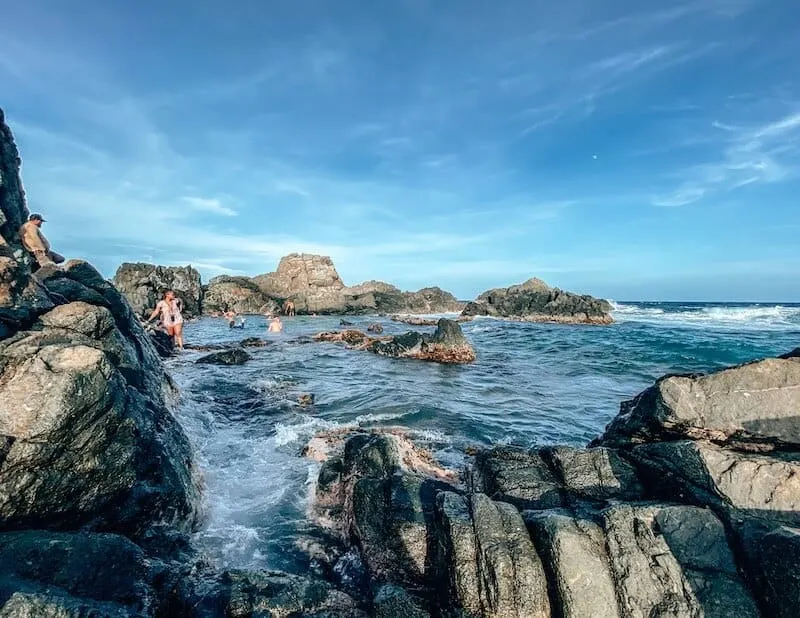 A natural pool surrounded by lava rock formations in Aruba