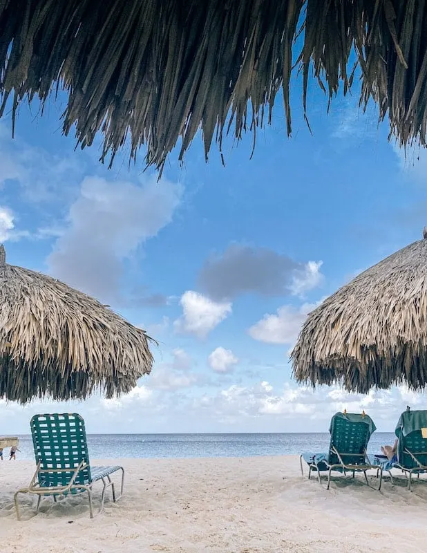 View of palapas and white sandy beach in Eagle Beach