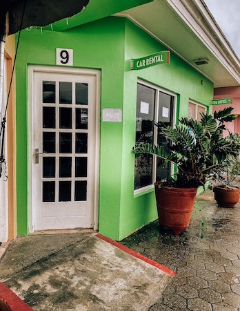 green exterior of a car rental office in Curacao