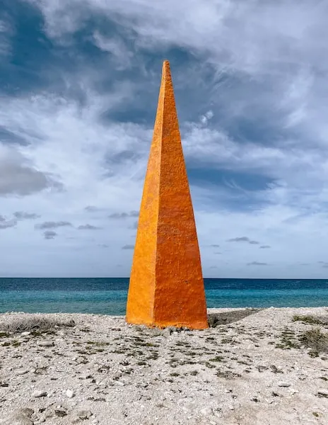 Orange and narrow pointy structure along the coast used for navigation in the past.