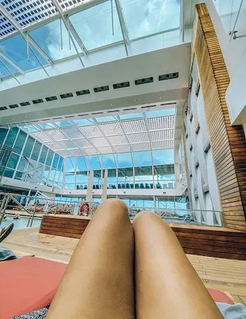 Peek of thighs and knees relaxing at a solarium pool
