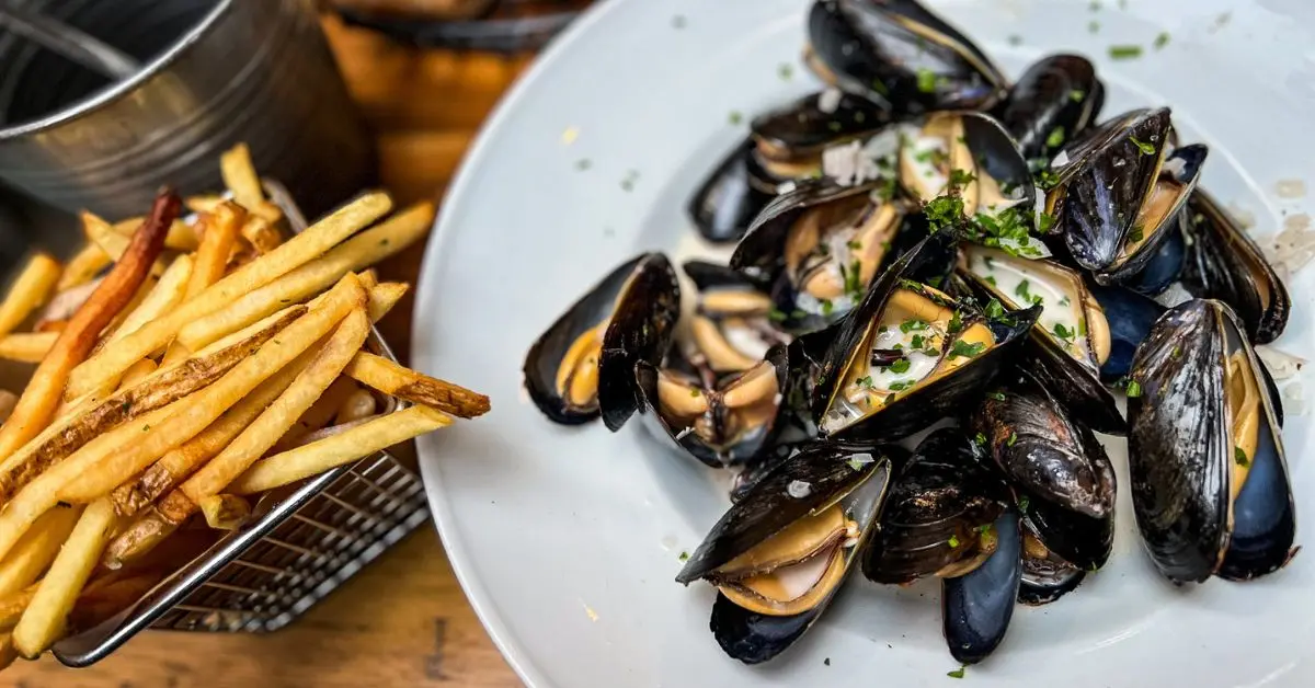 featured blog image without text of a plate of steamed mussels paired with a side of golden fries from entre nous restaurant in pasadena