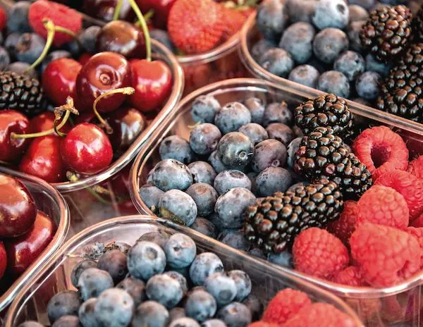 a mix of berries in tuperware containers