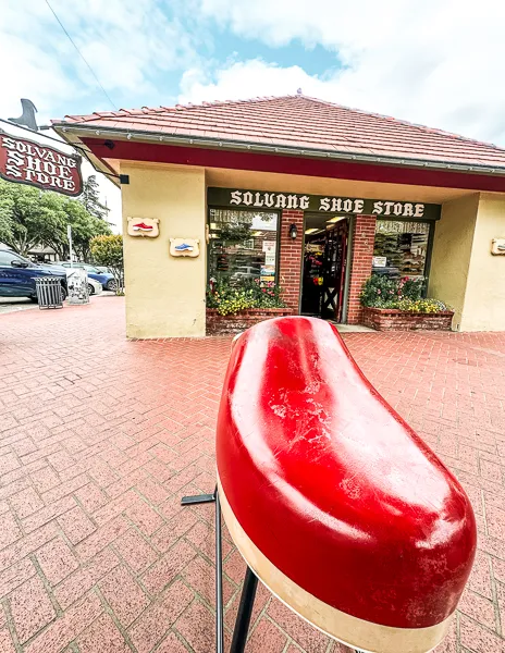 A large red wooden clog on display outside the Solvang Shoe Store