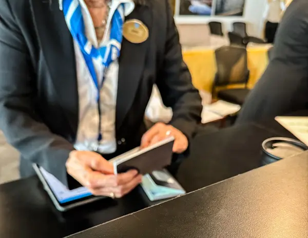 Cruise staff member checking a passenger’s passport during cruise embarkation