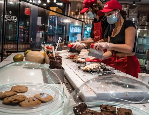 man and woman mixing in toppings into ice cream on a cold stone