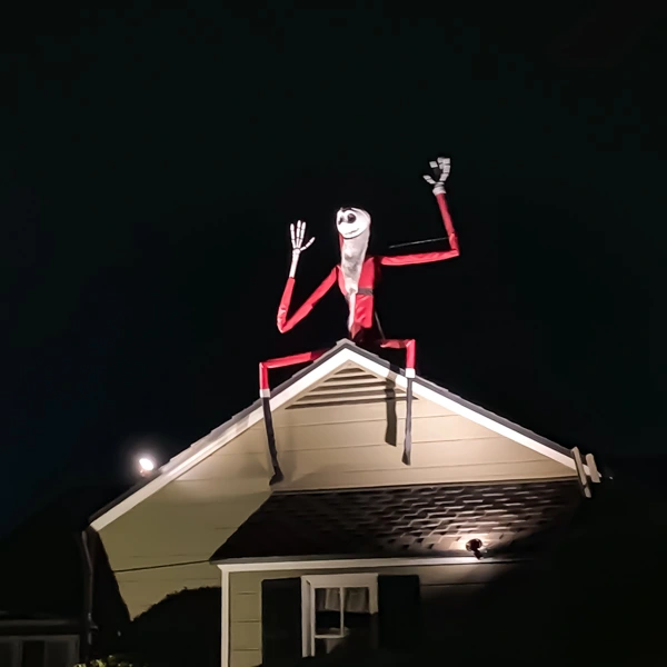 A festive Jack Skellington figure dressed as Santa sitting on the roof of a house in Upper Hastings Ranch, illuminated at night for the holiday season.