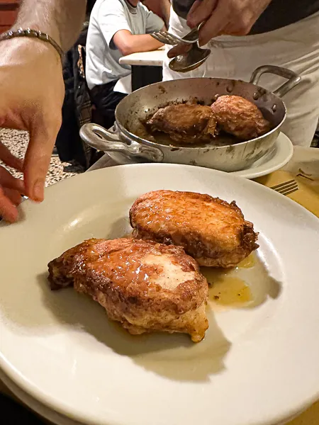  the simple yet mouthwatering pleasure of Trattoria Sostanza's famed buttered chicken. Golden and crispy on the outside, juicy on the inside, it's served straight from the pan to the plate, glistening with butter. 