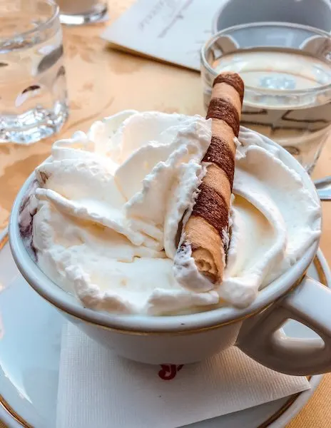 hot chocolate with whip cream with a batton cookie on top