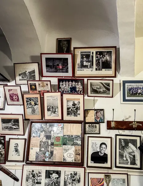 A collage of framed photographs and memorabilia adorning the wall of Trattoria Sostanza in Florence, showcasing a rich tapestry of history and cherished moments.