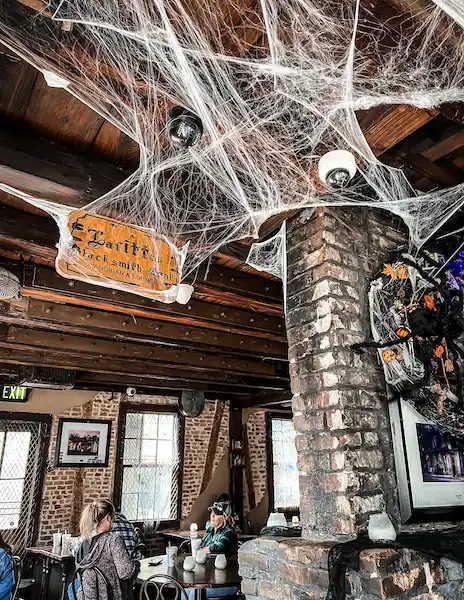 Inside Lafitte's Blacksmith Shop Bar in New Orleans, decorated with cobwebs for a spooky atmosphere during Halloweentime.