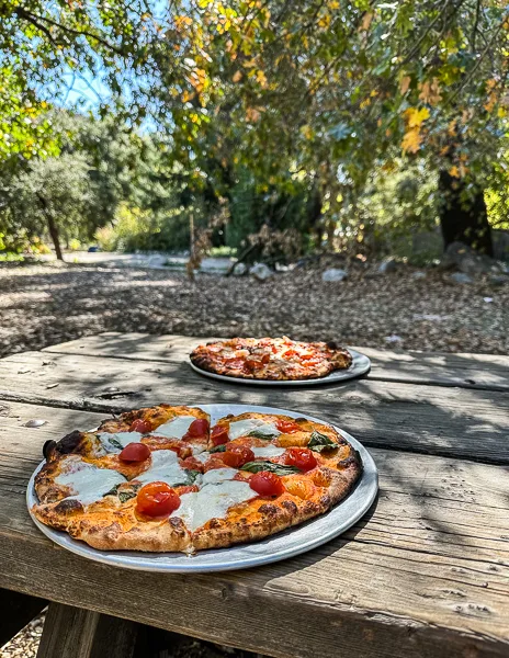 pizza on a picnic table outside at wilshires apple shed