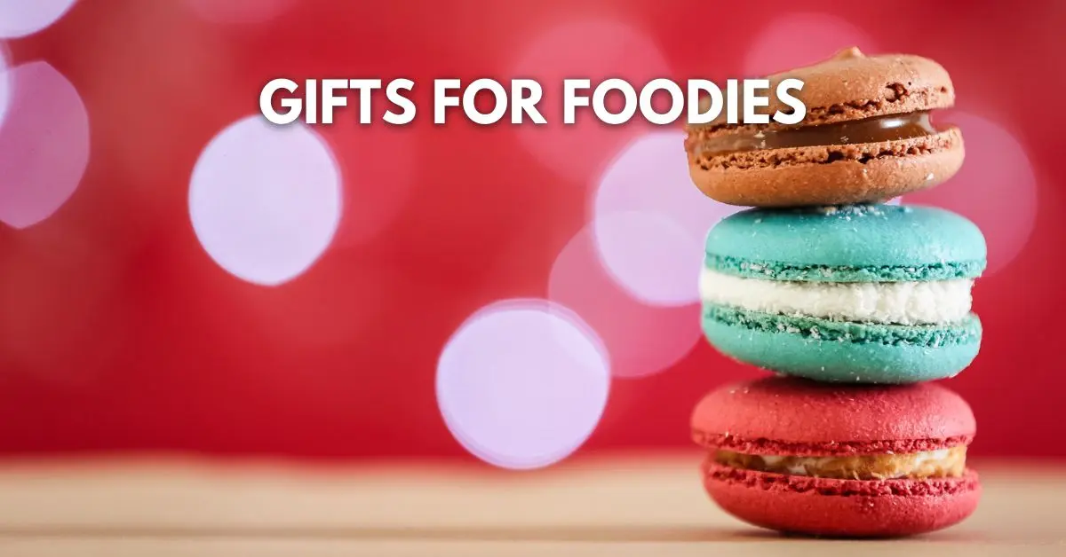 featured image: Stack of colorful macarons in front of a red background with bokeh lights and the text ‘Gifts for Foodies.’