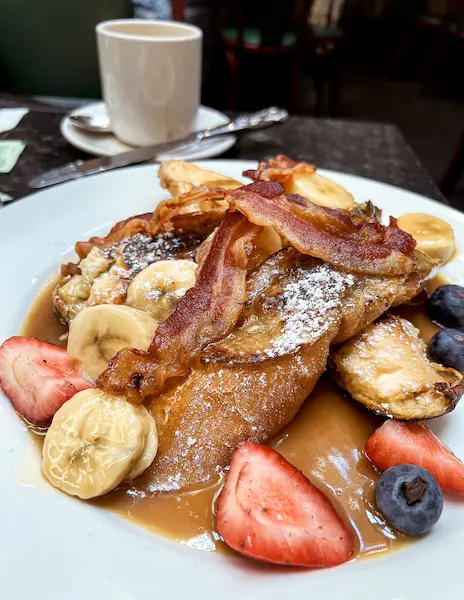 banana fosters french toast with berries and bacon on top