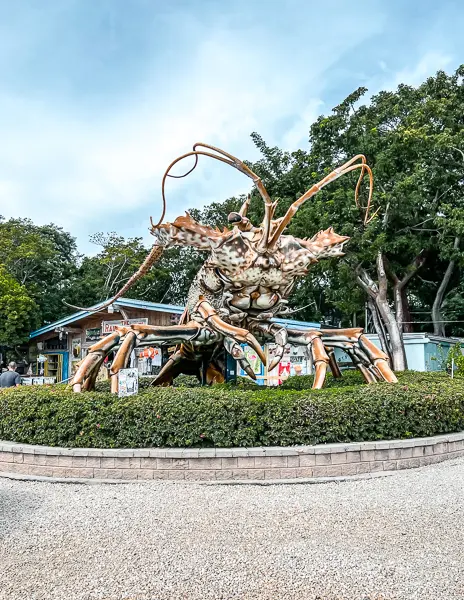 Betty the Giant Lobster statue in Islamorada, Florida, a popular roadside attraction surrounded by greenery and colorful shops in the Florida Keys.