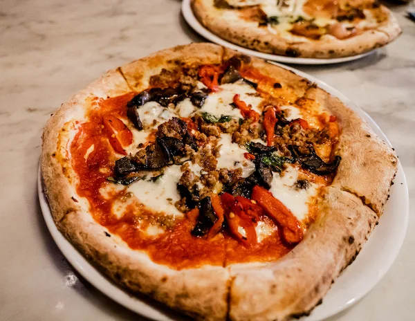 pizza with Tomato sauce, mozzarella, crumbled sausage, portabello mushroom, oven roasted red and yellow bell peppers, basil, extra virgin olive oil