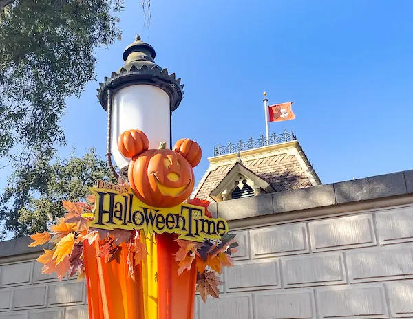 pumpkin on lightpost with Disney's Halloween time Sign