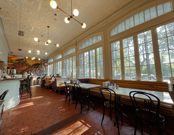 morning sun pours into the large windows of french toast restaurant in new orleans