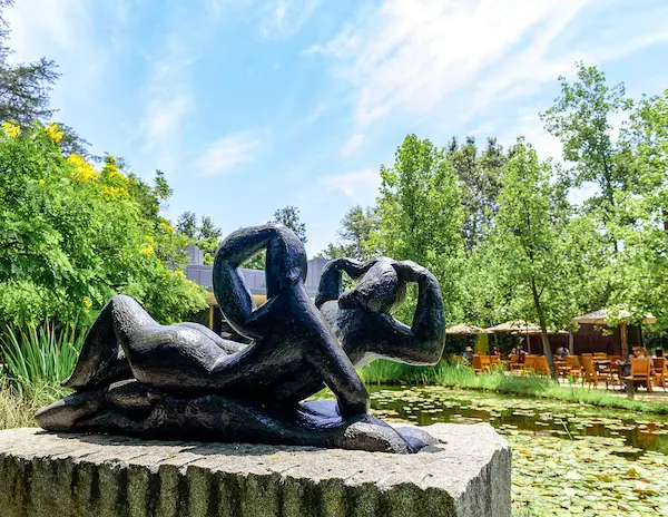 sculpture overlooking a pond and an ourdoor seating area