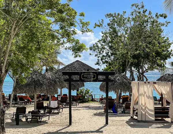 sandy beach with beach chairs, bed and ocean