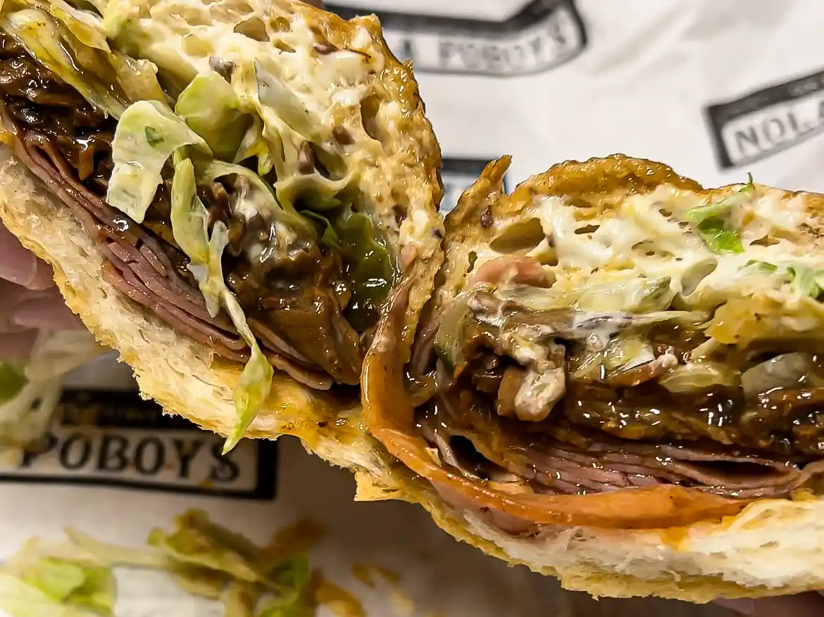 Close-up of The Big Easy po’boy loaded with roast beef, ham, gravy, lettuce, and mayo from NOLA Poboys in New Orleans.