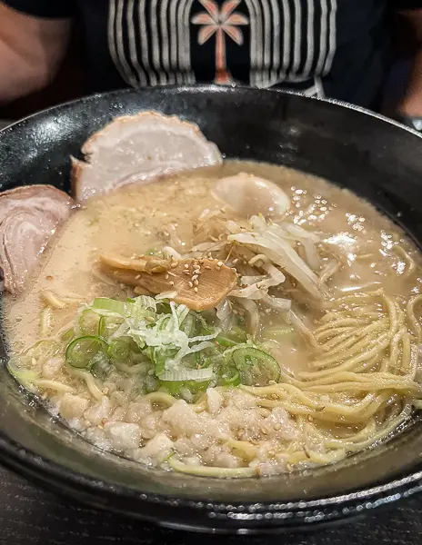 Bowl of ramen from Daikokuya in Little Tokyo featuring rich broth, noodles, sliced pork, green onions, and garlic chips.