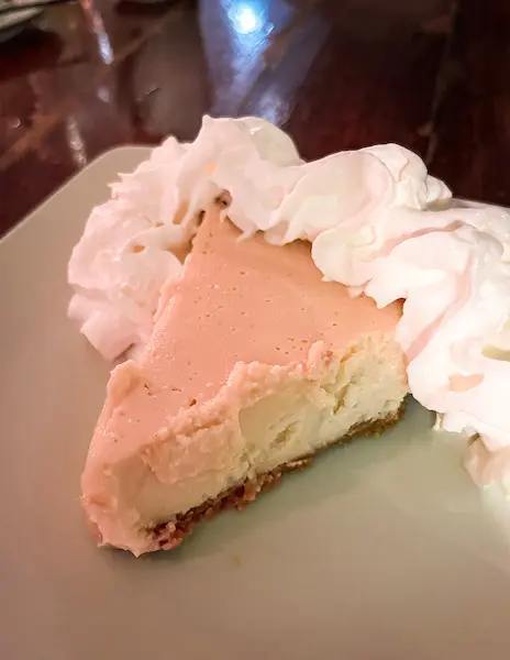 A slice of key lime pie from Lazy Day's with whipped cream on a plate.