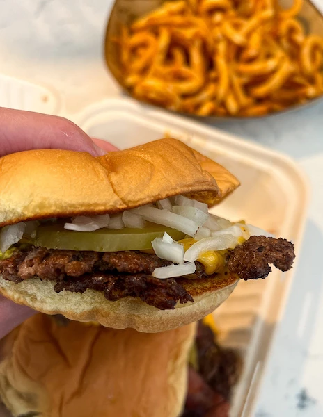 burger with smashed meat patty, onions and pickles