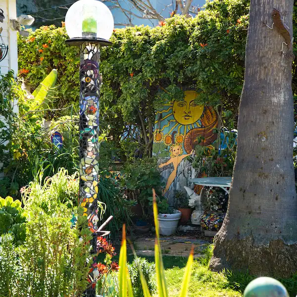 mosaic lamppost and artwork inside a garden
