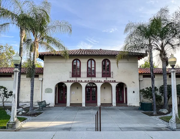 spanish style building with monrovia historical museum letters on it and flanked by palm trees