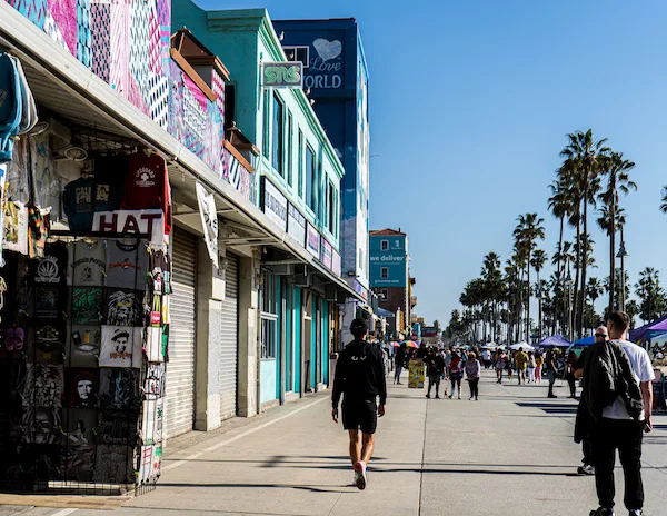 a glimpse at a souvenir shop and people walking along the boardwalk
