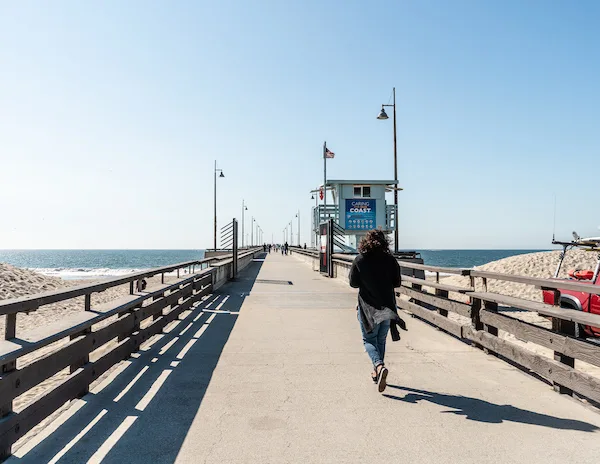 woman walking along a beach pier