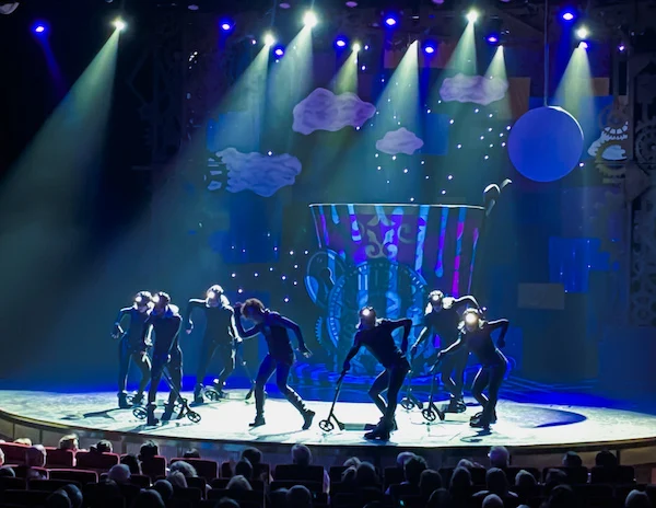 actors dressed in costumes on a dark stage