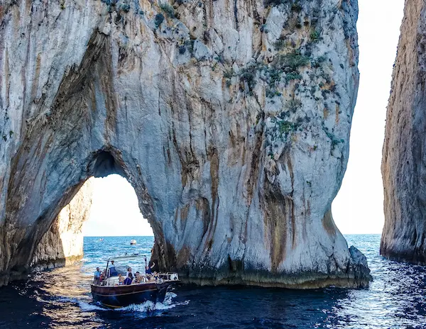 A boat in front of us going under the Faraglioni Rock.