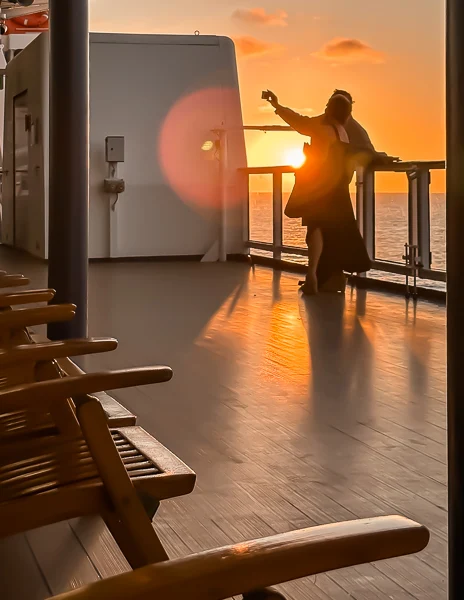 couple taking a photo at sunset on a cruise ship