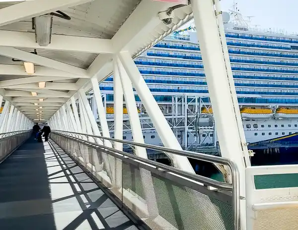 Walkway leading passengers onto a cruise ship on embarkation day, illustrating cruise embarkation day tips for boarding smoothly.