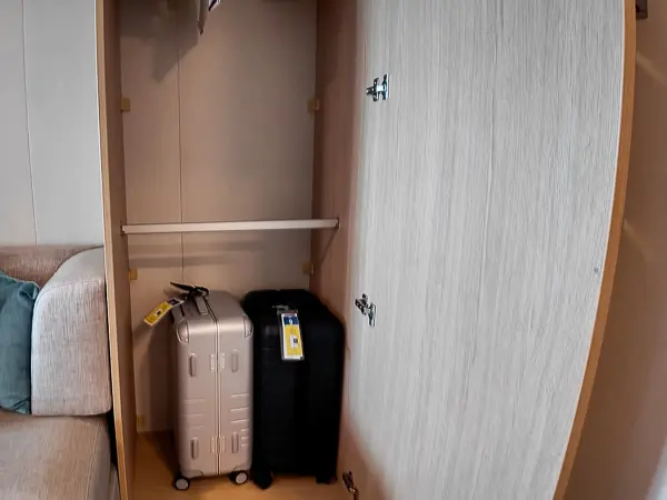 Two suitcases stored in a cruise cabin closet after boarding